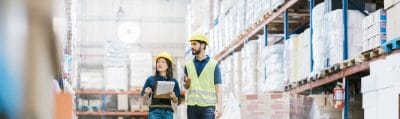 Two employees checking inventory on warehouse racks