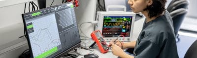 Technician repairing medical equipment at a workbench