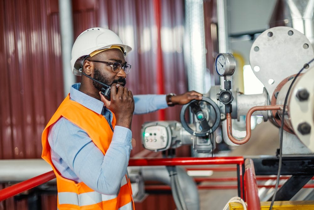 Engineer communicating on a radio in an industrial facility