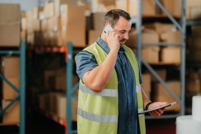 Employee on a phone call checking order details on a tablet