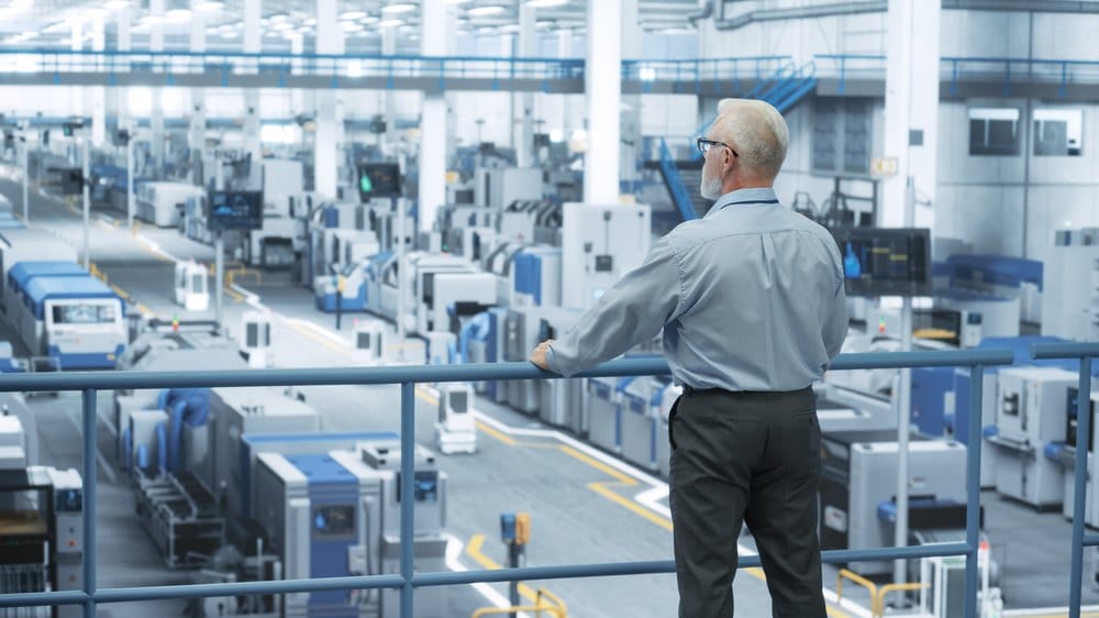 Industrial engineer overlooking an automated production hall