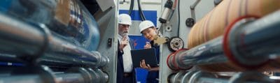 Industrial engineers reviewing work with a factory worker on the plant floor
