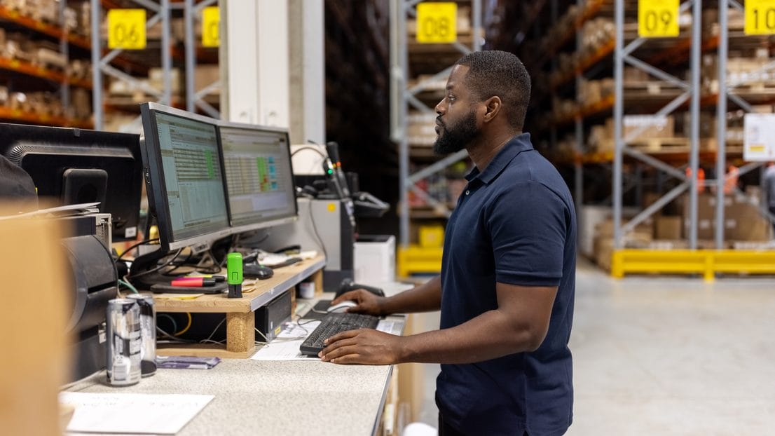 Maintenance manager submitting a repair request at a computer in a plant