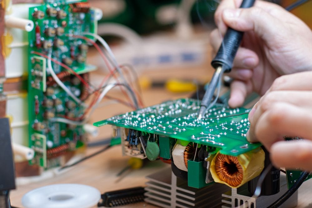 Technician reworking a faulty circuit board