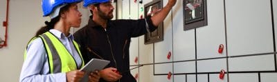 Electrical engineers checking systems in a power distribution control room