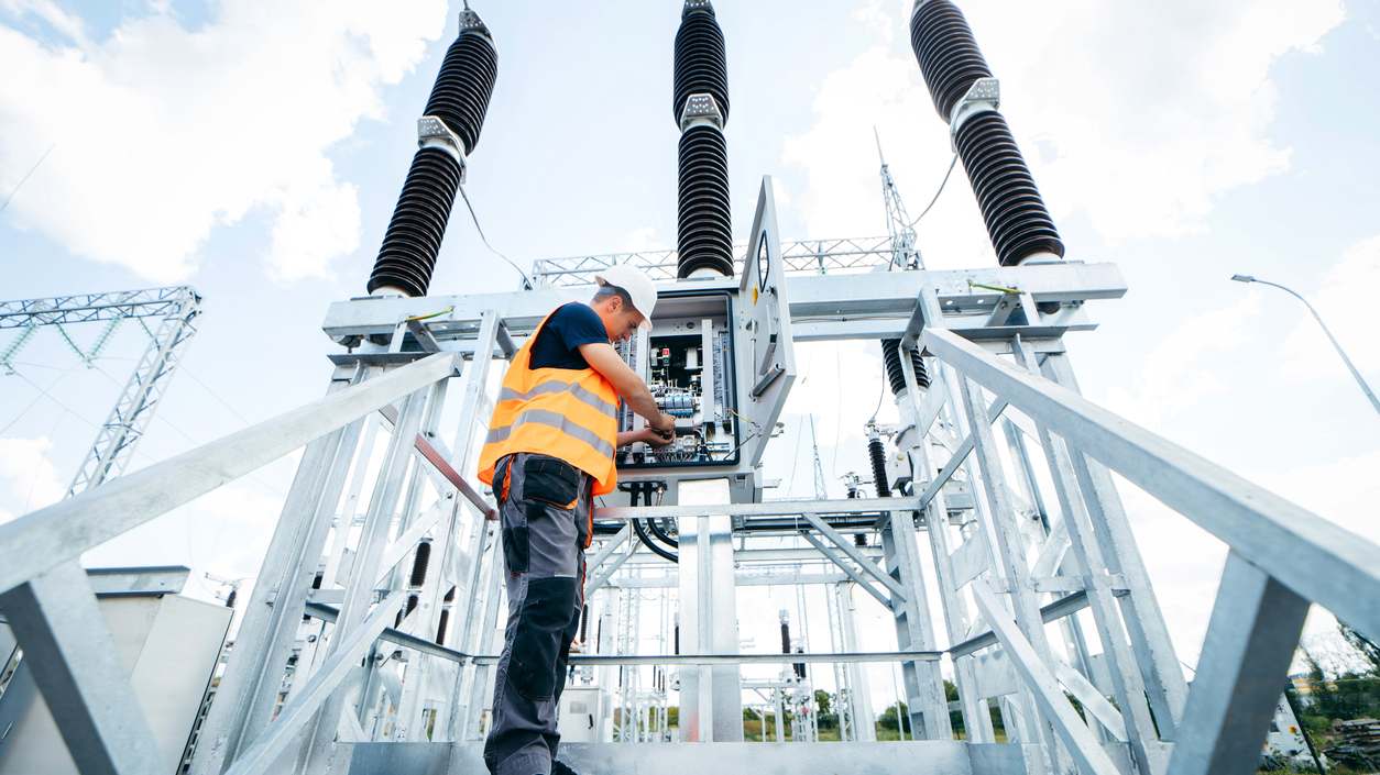 Electrical engineer inspecting systems at an equipment control cabinet