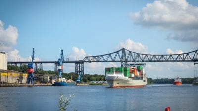Container ship passing under the Rendsburg High Bridge railway viaduct in Germany