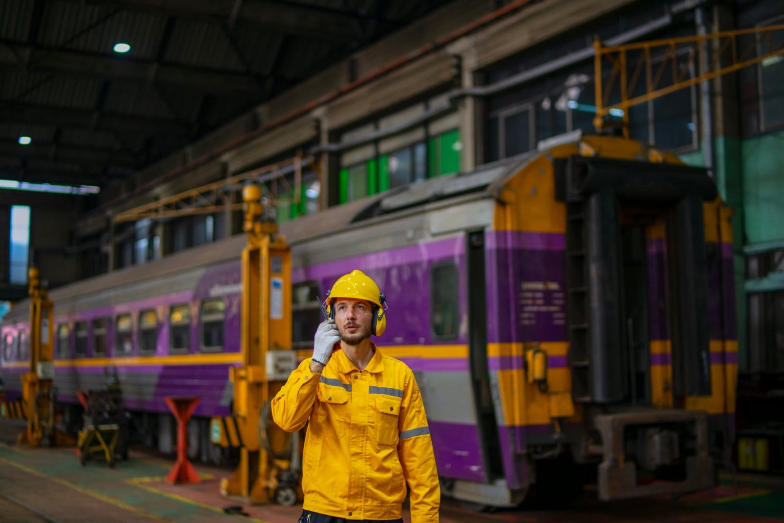 Technician with a radio working in a train maintenance depot